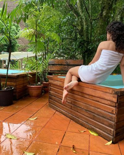 a woman sitting on a bench next to a swimming pool at Los Quetzales Ecolodge & Spa in Cerro Punta