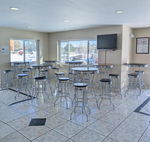 una stanza con tavoli, sgabelli e TV a schermo piatto di Days Inn by Wyndham Flagstaff I-40 a Flagstaff