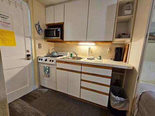 a small kitchen with a sink and a microwave at Mandaly Bay Efficiency Comfort in Clearwater Beach