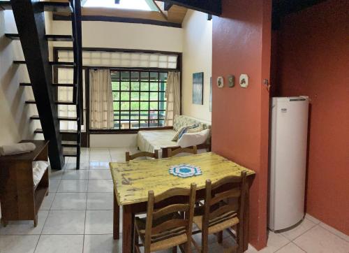 uma sala de jantar com uma mesa e um frigorífico em Chalé Aconchegante em Garopaba