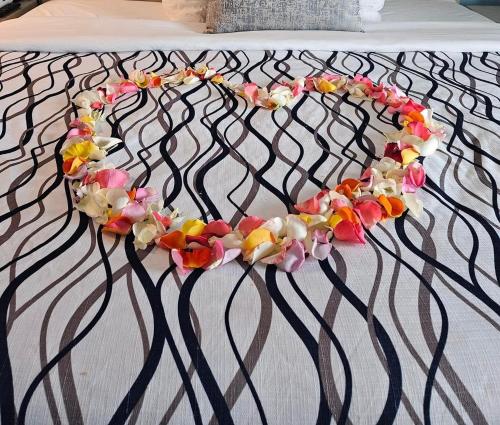 a headboard with a necklace of flowers on a bed at Ocean Sands Beach Boutique Inn-1 Acre Private Beach-St Augustine Historic-2 Miles-Shuttle with Downtown Tour-HEATED Salt Water Pool until 420AM-Popcorn-Cookies-New 4k USD Black Beds- 69 Item Breakfast-Eggs-Bacon-Starbucks- Free Laundry- #904-799-SAND in Saint Augustine