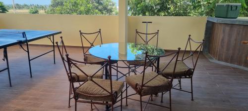 uma mesa de vidro e cadeiras num pátio em El Bungalow de Don Guillermo de Imperial 