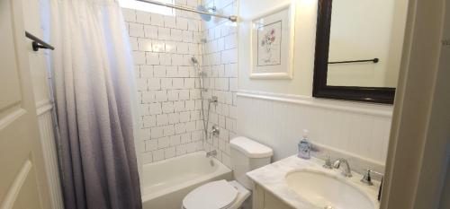 La salle de bains blanche est pourvue de toilettes et d'un lavabo. dans l'établissement La Belle Cottage II 2queenbeds 10min to French Qtr, à La Nouvelle-Orléans