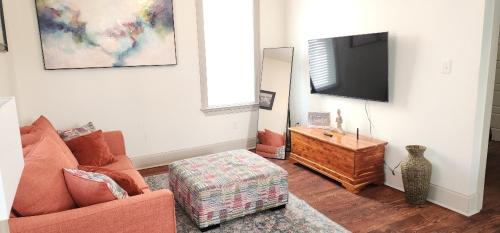 a living room with a couch and a flat screen tv at La Belle Cottage II 2queenbeds 10min to French Qtr in New Orleans
