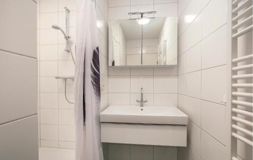 Baño blanco con lavabo y espejo en Beautiful Home In Bruinisse With Kitchen, en Bruinisse