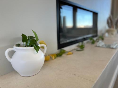 a white vase sitting on a counter with a plant in it at Canyon Mesa Haven, Luxury Stay near Lake Powell in Big Water