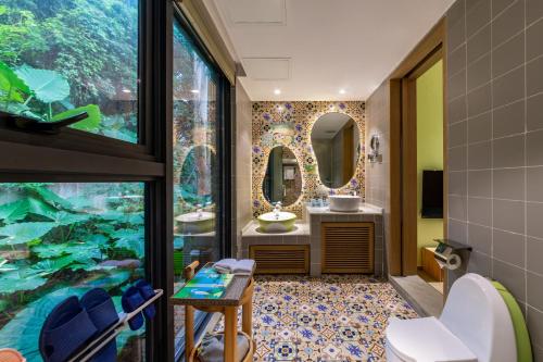a bathroom with two sinks and a large window at Little Hakka Hotel in Shenzhen