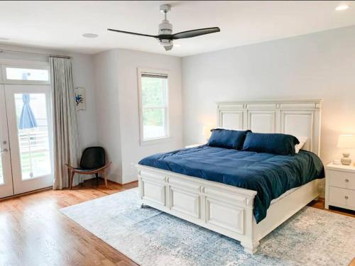 a bedroom with a large bed with a blue blanket at City View- near Downtown, Capital, NC State in Raleigh