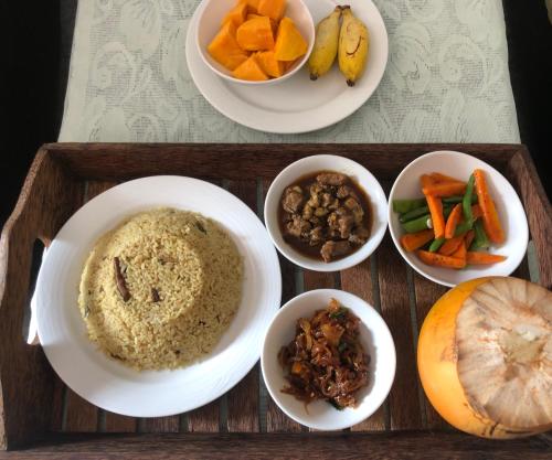 a tray of food with bowls of food and vegetables at Luvi’s Villa in Galle