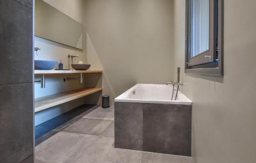 ein Badezimmer mit einer Badewanne und einem Waschbecken in der Unterkunft Stunning Home In Dwingeloo With House A Panoramic View in Dwingeloo