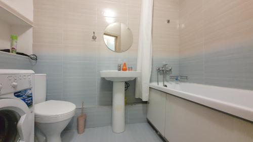a bathroom with a sink and a toilet and a bath tub at 27 1 комн кв с кондиционером возле Байтерка на 4х человек in Astana