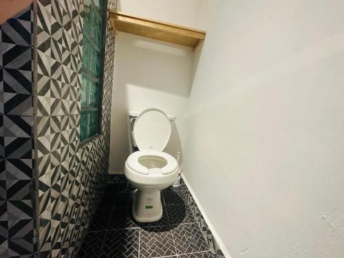 La salle de bains est pourvue de toilettes blanches. dans l'établissement The Stay Doña White, à Matamoros