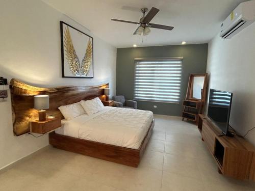 a bedroom with a bed and a flat screen tv at Kobikhome in Cancún