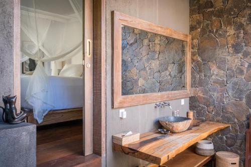 a bathroom with a sink and a bed at Flow Gili Air in Gili Air