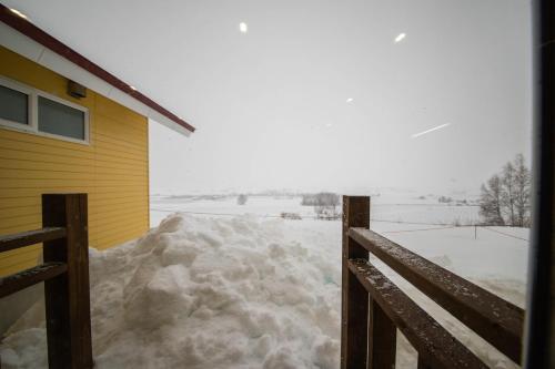 una pila de nieve junto a una casa en THE NORTH PEAK NAKAFURANO, en Nakafurano