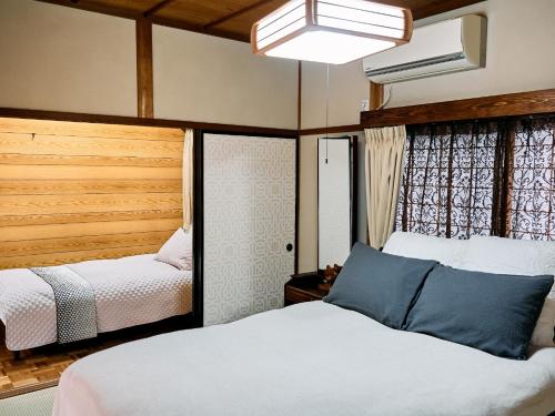 1 dormitorio con 2 camas y ventana grande en MIU HOUSE - Vacation STAY 30561v, en Izumo