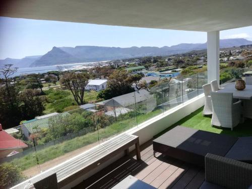 a living room with a large window with a table and chairs at Mountain & Sea Apartments in Kommetjie