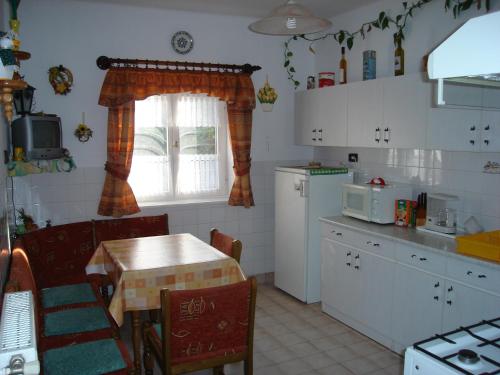 a kitchen with a table and a table and a window at Park Nyaralóház in Badacsonytomaj