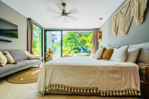 a bedroom with a large bed and a couch at Luz de Luna Tulum Suite II in Tulum