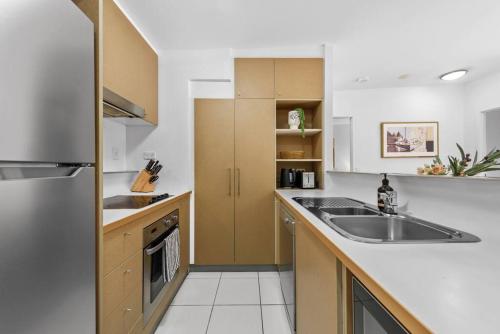 a kitchen with a sink and a refrigerator at Home away from Home! 2Bed/1Bath/Car/Pool~2kms CBD in Brisbane
