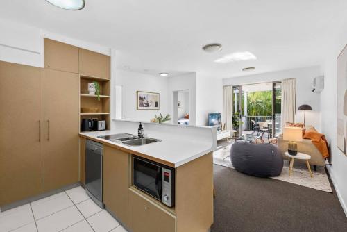 a kitchen with a sink and a living room at Home away from Home! 2Bed/1Bath/Car/Pool~2kms CBD in Brisbane