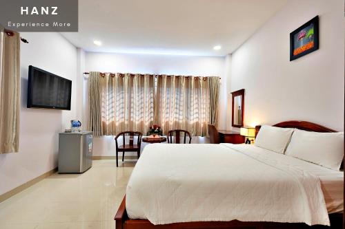um quarto de hotel com uma cama e uma mesa em HANZ Hoang Hoang Hotel Ben Thanh em Ho Chi Minh
