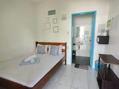 a bedroom with a large bed and a bathroom at Hashtag Tourist Inn in San Vicente