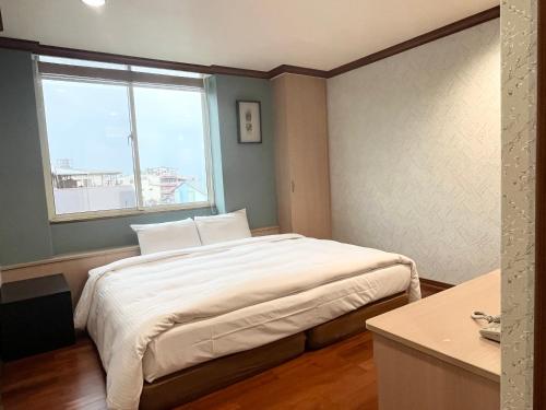 a bedroom with a large bed with a window at 日月潭魚池鄉秀水民宿Xiu Shui Hotel in Yuchi