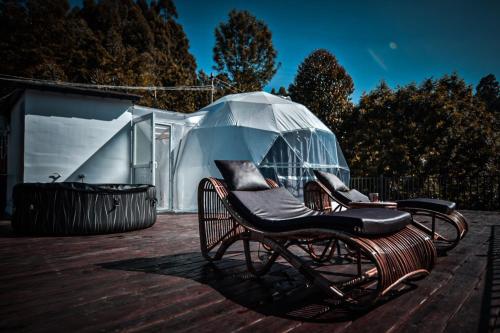 einen Stuhl auf einem Deck mit einem klaren Schirm in der Unterkunft Divercity Luxury Glamp in Kodaikanal