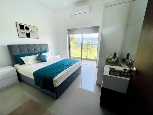 - une chambre avec un lit et une grande fenêtre dans l'établissement The Golf View, à Gonapola
