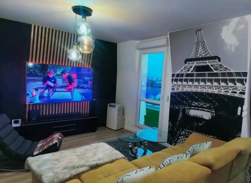 sala de estar con sofá y torre eiffel en Superbe appartement en Gagny