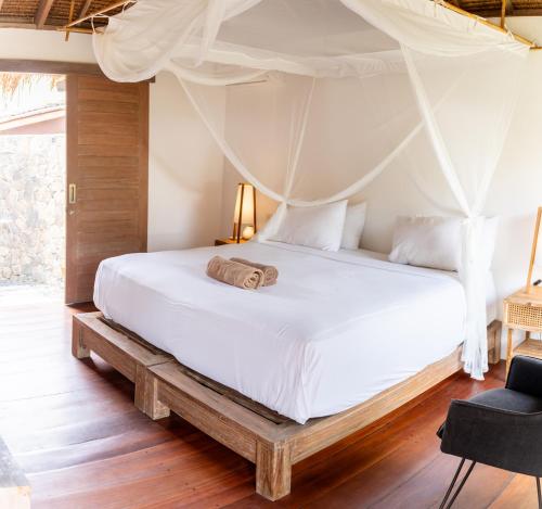 Flow Gili Air في غيلي آير: غرفة نوم بسرير أبيض مع مظلة