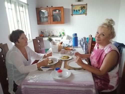 ゴールにあるUma Beach Homeの2人の女性がテーブルに座って食事している