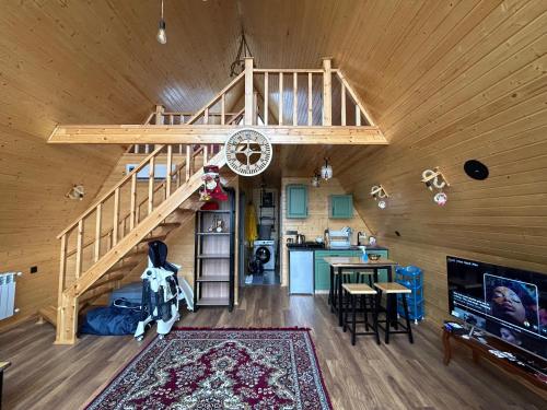 uma sala de estar e cozinha com uma escada num chalé em A Frame Lankaran em Lankaran