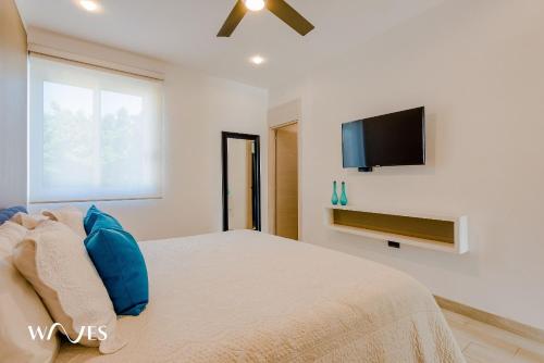 a bedroom with a bed and a flat screen tv at 1 Rec. | A pasos de la playa | Piscina en Terraza in Playa del Carmen