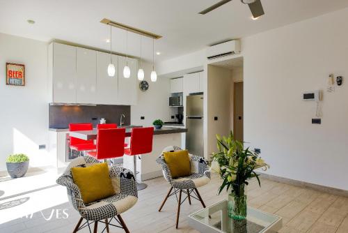a kitchen and living room with red chairs and a table at 1 Rec. | A pasos de la playa | Piscina en Terraza in Playa del Carmen