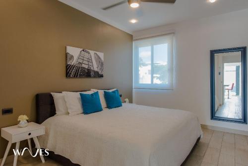 a bedroom with a large bed with blue pillows at 1 Rec. | A pasos de la playa | Piscina en Terraza in Playa del Carmen