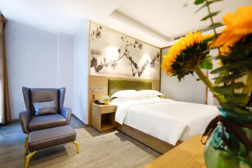 une chambre d'hôtel avec un lit et une chaise dans l'établissement Guangzhou Huihe Hotel, à Canton