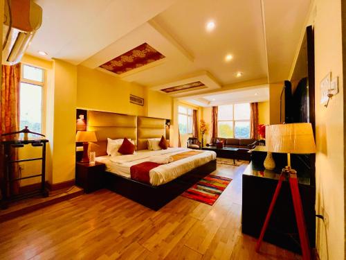 a bedroom with a bed and a living room at The Rio Lodge, Haridwar in Haridwār