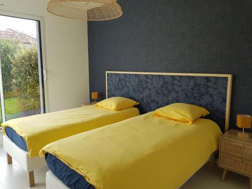 two beds sitting next to each other in a bedroom at 9 pers 160 M² +jardin- 10mn Nantes -30mn mer in Bouguenais