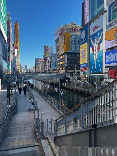 a bridge over a river in a city with buildings at Osaka Namba Hostel MIYABI in Osaka