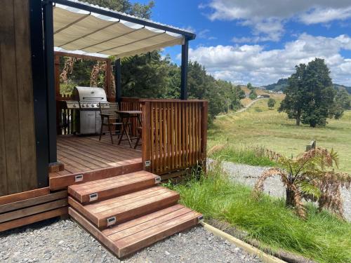 a cabin with a deck with a grill and a grill at Bush Cabin Stunning views in Taumarunui