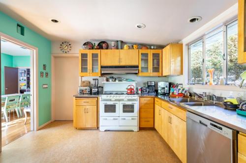 a kitchen with wooden cabinets and a white stove top oven at Bixby Beauty 50s Mod Long Beach in Long Beach