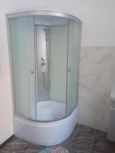 a shower with a glass enclosure in a bathroom at Старий Дворик,кімнати біля жд вокзалу in Lviv