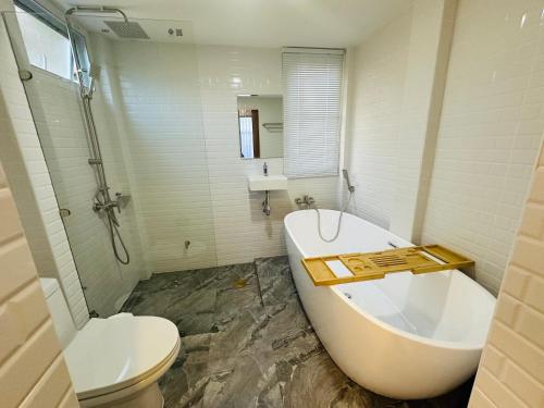 ein Badezimmer mit einer Badewanne, einem WC und einem Waschbecken in der Unterkunft Pai Cheese cottage in Pai