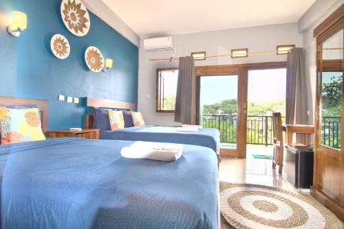 a bedroom with two beds and a balcony at Hotel Bonne Nuit in Labuan Bajo