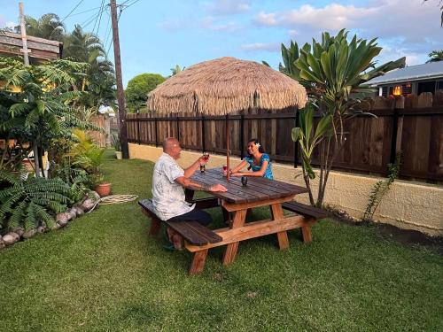 a man and a woman sitting at a picnic table at La maison près du Phare in Mahina