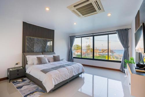 ein Schlafzimmer mit einem großen Bett und einem großen Fenster in der Unterkunft Anda Sea View Pranburi in Ban Pak Nam Pran