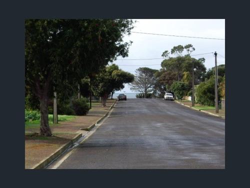 an empty street with cars parked on the side of the road at Sally's Kingscote Retreat-2 units with 4 bedrooms in Kingscote, Kangaroo Island in Kingscote