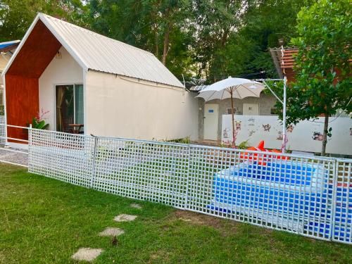 a blue fence in front of a house at เดอะมินิมอล นอร์ดิกเฮ้าส์The Minimal Nordic House By The Mountain Ozoneบ้านโอโซนขุนเขาแก่งกระจาน in Kaeng Krachan